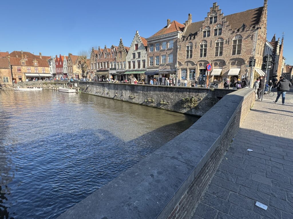 A river flows beneath a bridge, flanked by buildings on both sides, showcasing a scenic urban landscape.